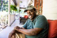 Man smiling on porch.